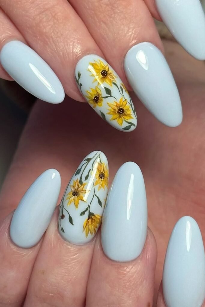 Soft whites and vibrant yellows come together in these fresh, floral-inspired nails that feel like a gentle summer breeze. The blue polish serves as the perfect airy backdrop, allowing intricate sunflower nail designs to pop effortlessly.