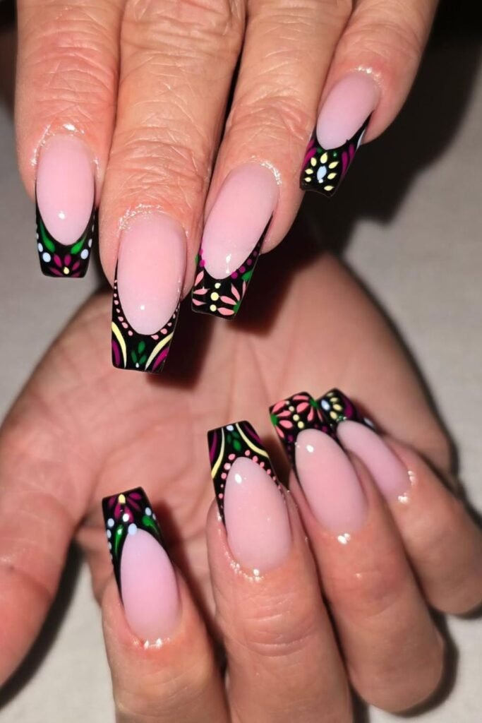 These nails are all about contrast. The soft pink base creates a delicate, chic look, while the bold black tips bring drama. featuring colorful floral accents! Bright greens, pinks, and yellows pop against the dark tips, making these nails feel fresh and artistic.