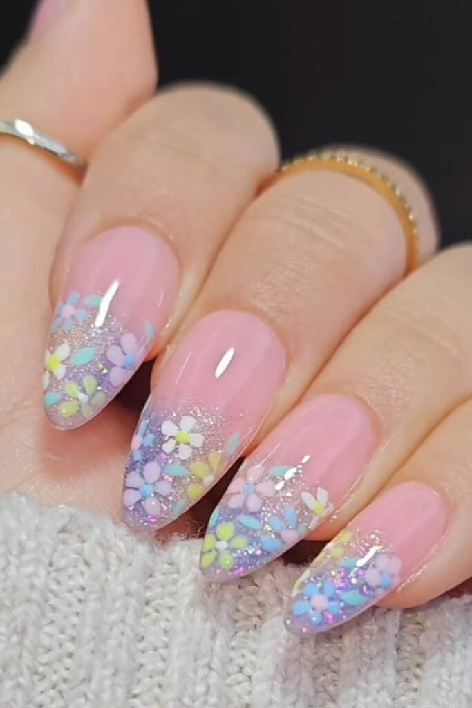 Picture this: delicate hand-painted flowers sprinkled with just the right amount of glitter.
On almond-shaped nails, it’s pure spring magic