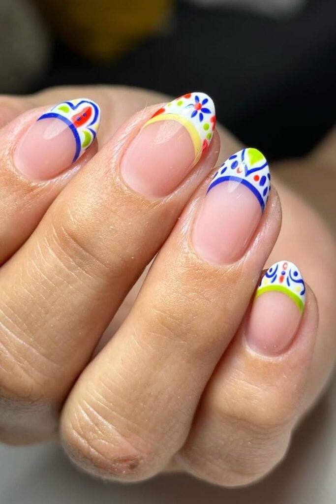 Mexican Fiesta Colorful Tips brings together bold hues – blue, red, yellow, and green combined with intricate dots and artistic details on the nail tips. The contrasting base keeps the design fresh while letting the Mexican nail designs shine.
