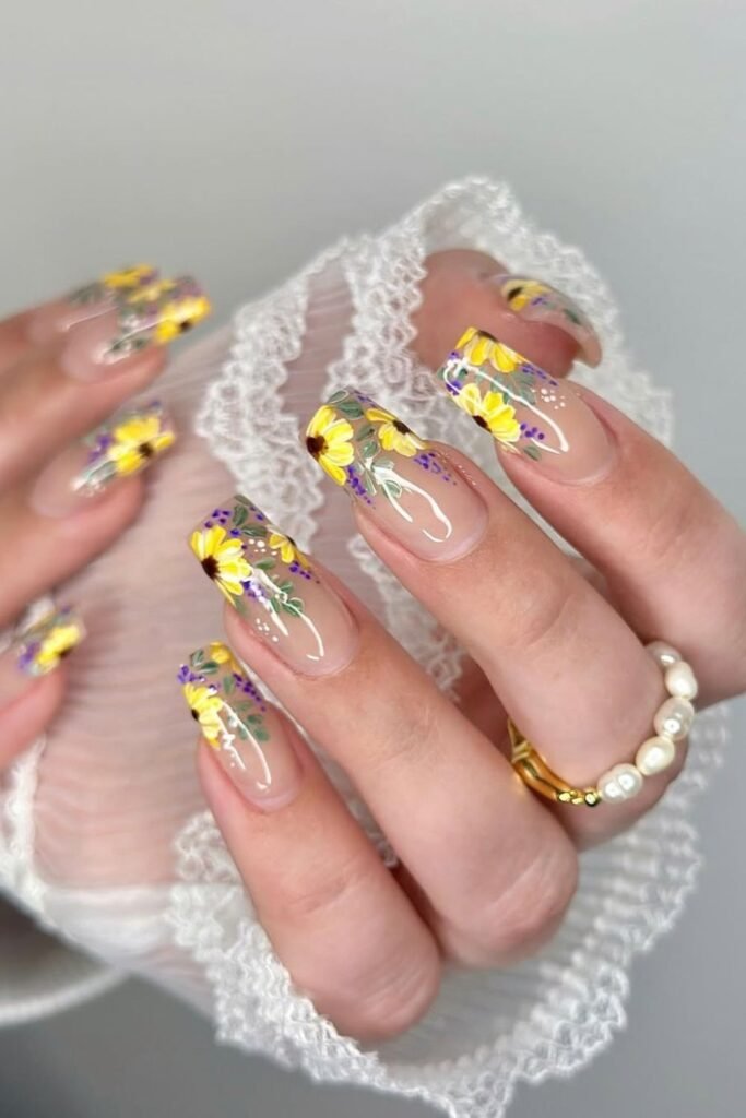 These sunflower nails are a beautiful mix of floral artistry and sheer sophistication. Featuring delicate sunflower nail art with soft yellow and purple blooms, these nails exude a fresh, radiant charm. The intricate details of sunflower nail designs complement the natural, clear base, making them a perfect choice for anyone who loves cute sunflower nails.