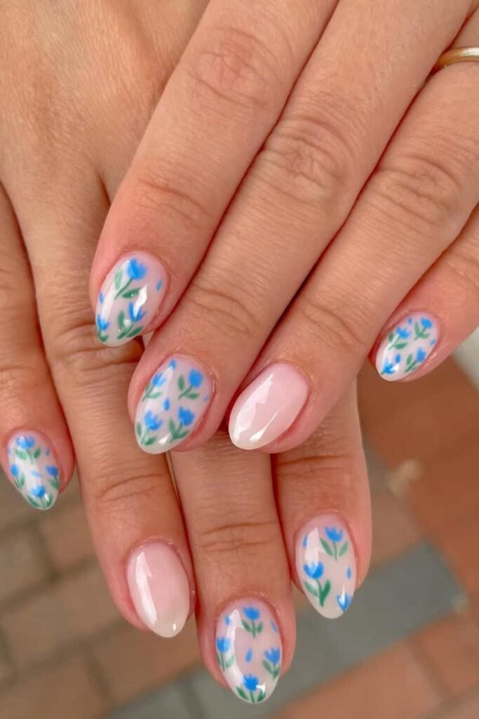 Peach nails with blue floral designs.