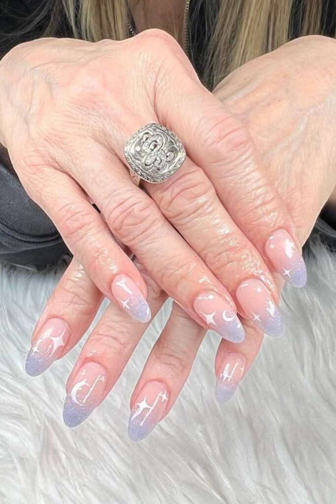 Ombre nails with sun and star motifs.