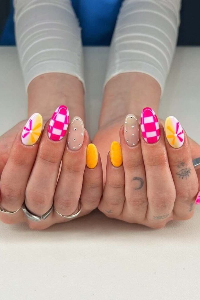 Mixed design nails with clouds, citrus, and checkerboard art.
