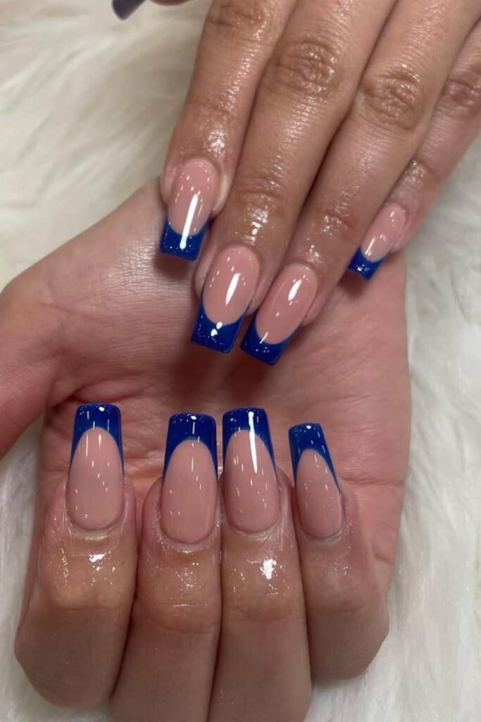 Nude nails with bold blue French tips.