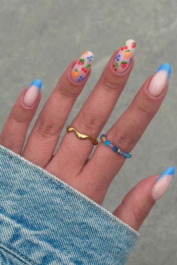 Bright blue French tip summer nails with fruit accents.