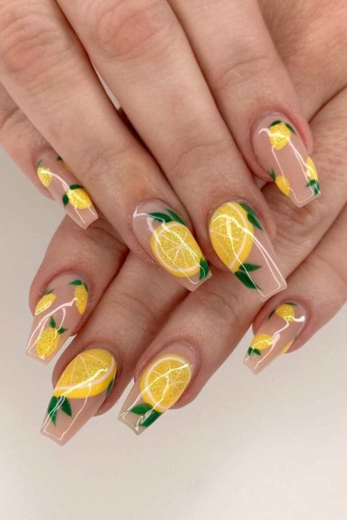 Nude nails with lemon and green leaf art.