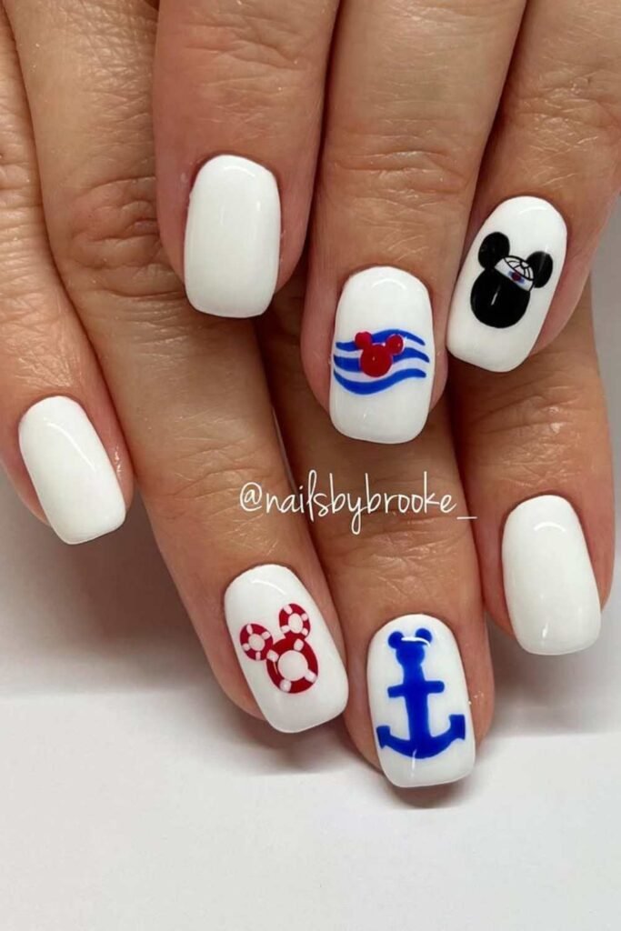 White nails with red nautical and Mickey-inspired designs.