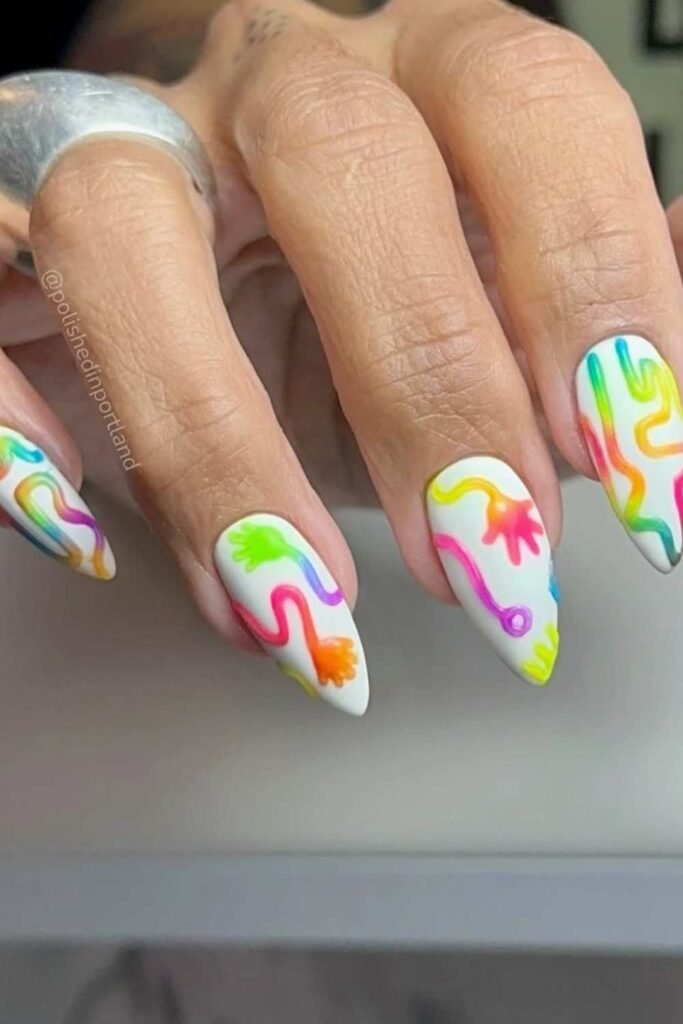White nails with rainbow-colored designs.